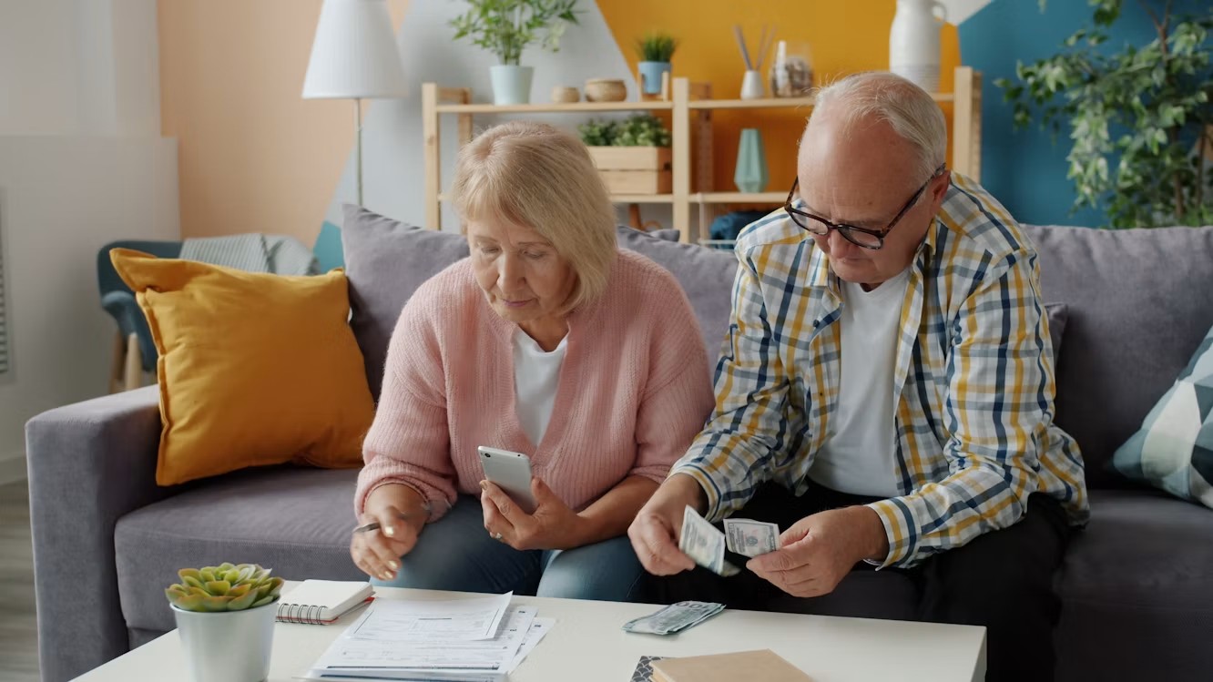 Pareja de adultos mayores revisando sus finanzas en casa